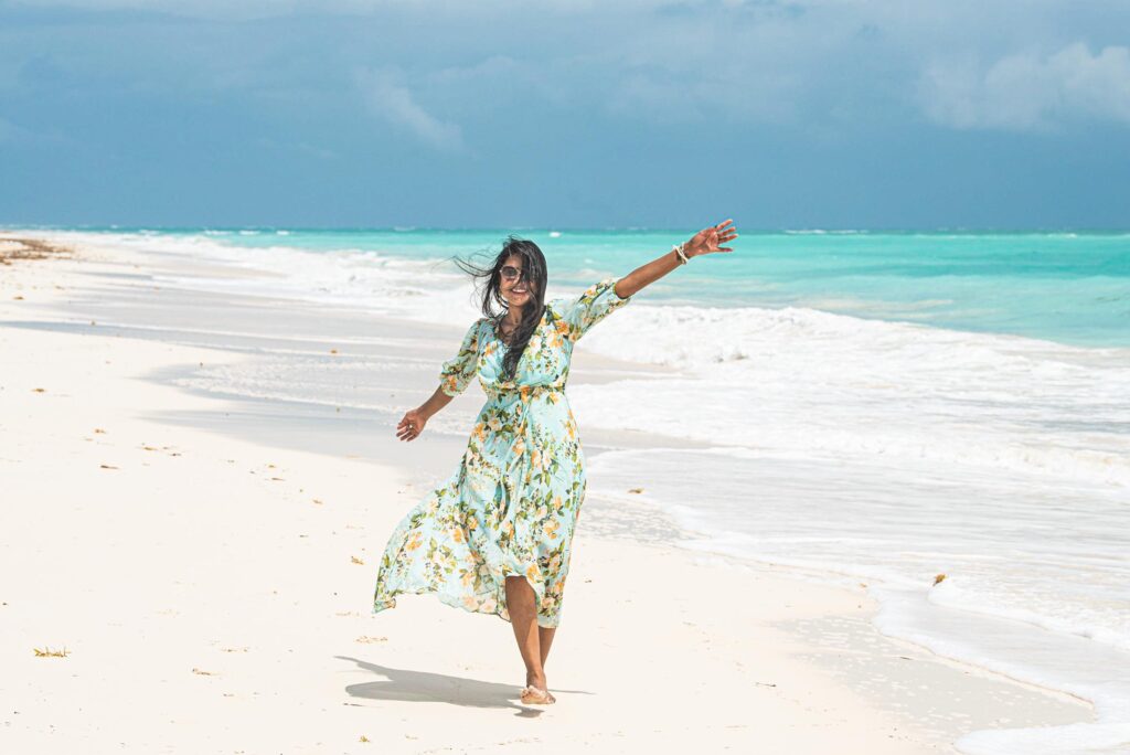 A woman walking at the beach in the turquoise waters of the Mexican Caribbean