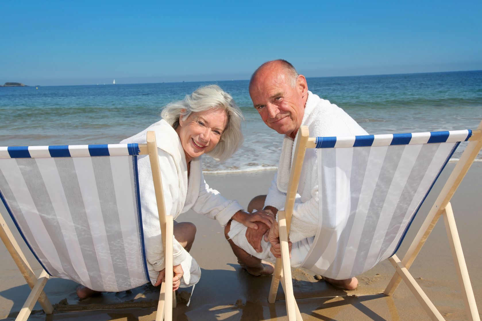 An elderly couple lying at the beach